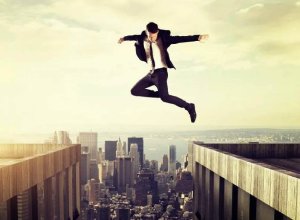 A man jumping across the top of two buildings