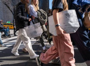 people walking across street with shopping bags