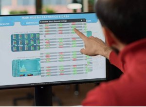 man pointing at computer data on screen