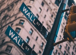 A photograph of a Wall Street sign and a traffic light.