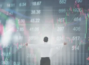 A man standing in front of a stock ticker.